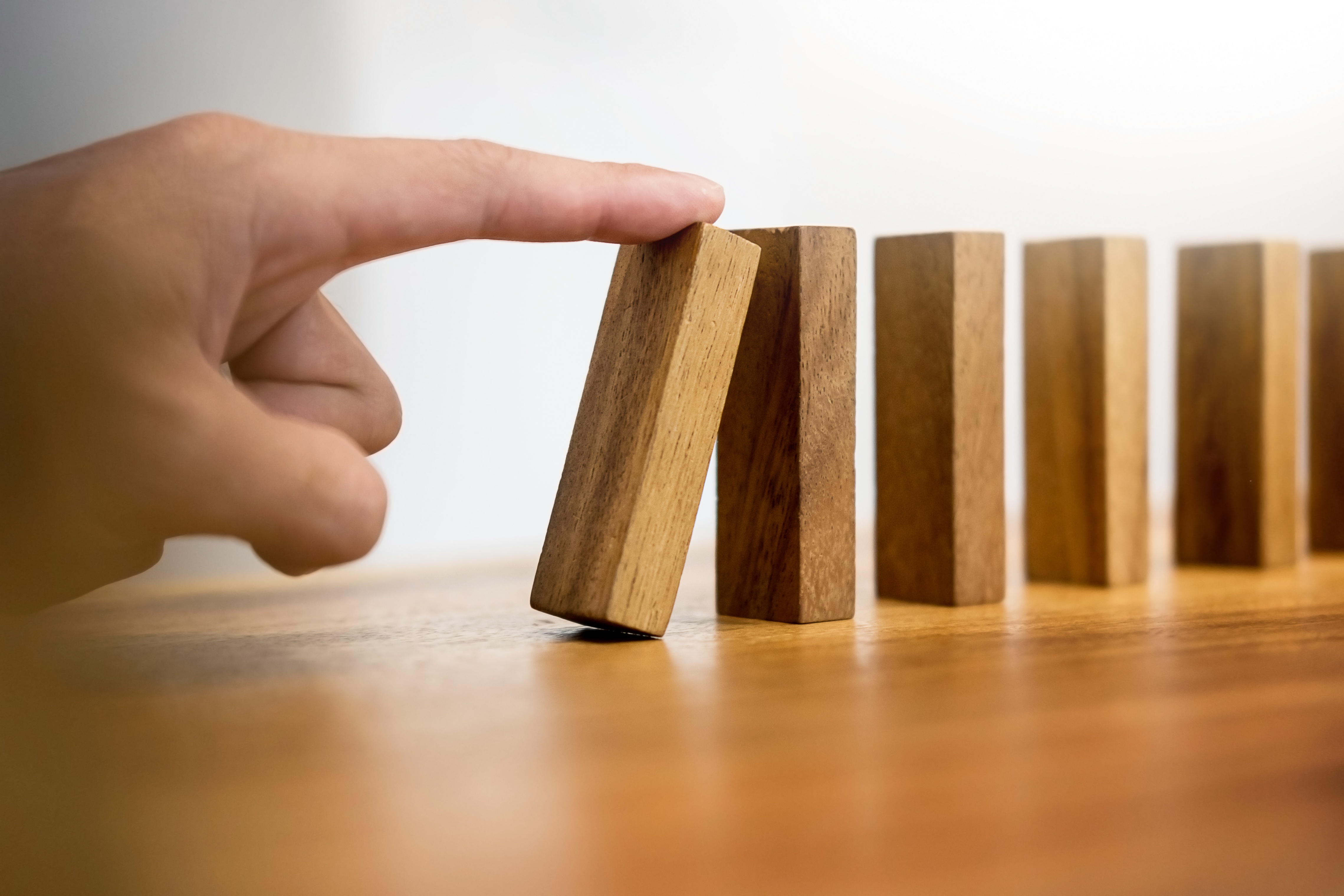 Hand Pushing Dominos stock photo